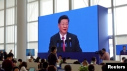 记者们在博鳌论坛会场的新闻中心观看中国国家主席习近平讲话。（2018年4月10日）