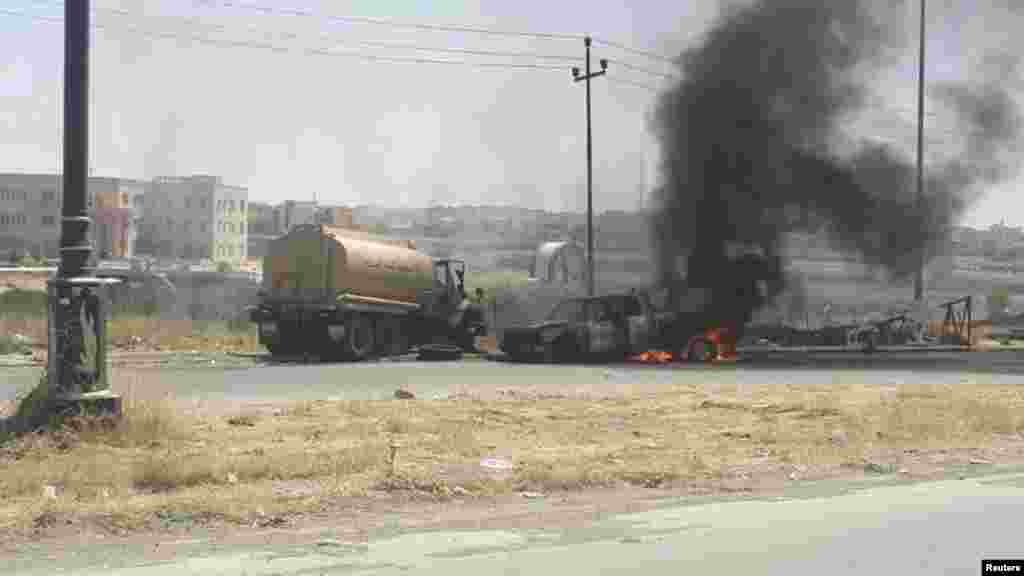 Burning vehicles belonging to Iraqi security forces are seen during clashes between Iraqi security forces and al-Qaida-linked Islamic State in Iraq and the Levant in Mosul, Iraq, June 10, 2014.