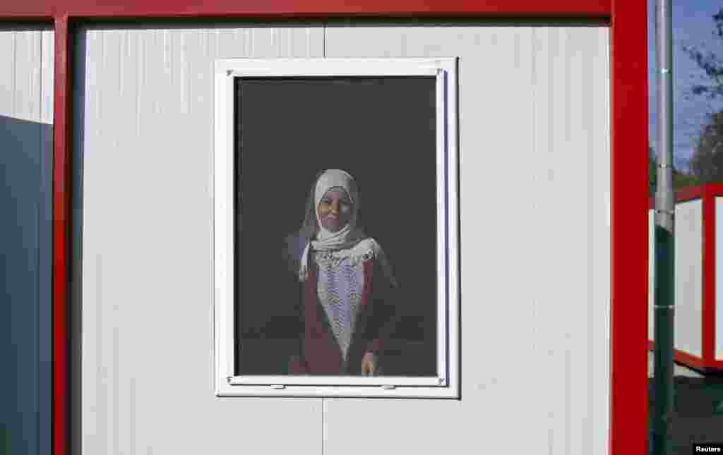 A Syrian woman looks out of the window of a container home at the refugee camp in Harmanli, 280km (174 miles) east of Sofia December 9, 2013.