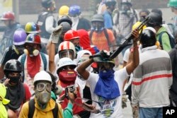 An anti-government demonstrator shows a shotgun taken from security forces during clashes in Caracas, Venezuela, May 8, 2017.