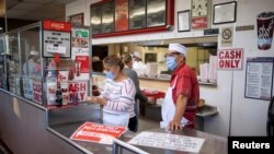 Trabajadores de un restaurante de El Paso, Texas, cumplen las restricciones por el coronavirus el 15 de noviembre de 2020.