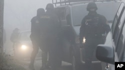 Bosnian policemen secure an urban area in a Sarajevo suburb during a raid targeting suspected terrorists in Sarajevo, Bosnia, on Tuesday, Dec. 22, 2015.