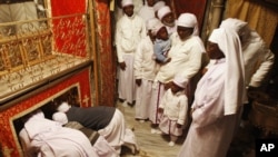 Des chrétiens du Nigeria prient dans la grotte de l'église de la Nativité, considérée comme lieu de naissance de Jésus-Christ, à Bethléem en Cisjordanie. 24 décembre 2012 (AP Photo/Adel Hana)