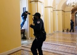 Seorang petugas polisi Capitol AS menembakkan semprotan merica ke seorang pengunjuk rasa yang mencoba memasuki Gedung Capitol di Washington, AS, 6 Januari 2021. (Foto: Reuters)