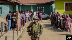 Foto ilustrasi yang menunjukkan seorang tentara India menjaga salah satu tempat pemungutan suara di Shadipora, di utara Srinagar, wilayah Kashmir yang dikontrol oleh India, pada 20 Mei 2024. (Foto: AP/Mukhtar Khan)