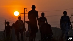Migrantes caminan al amanecer por la carretera que atraviesa Arriaga, estado de Chiapas, un paso peligroso en el sur de México, el lunes 8 de enero de 2024, durante su viaje hacia el norte hacia la frontera con Estados Unidos.