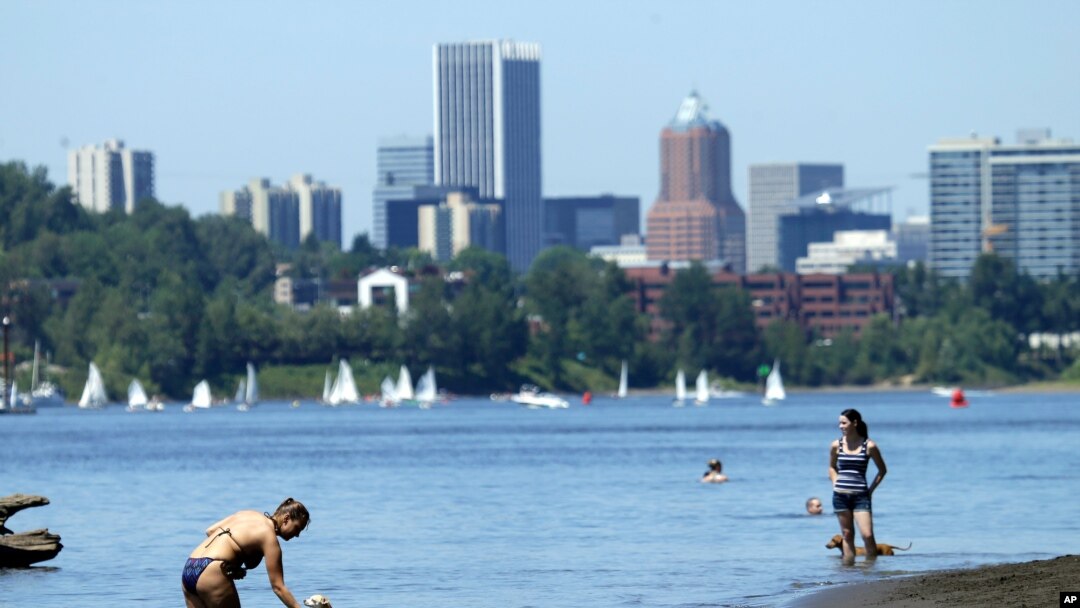 ARCHIVO - Personas, mascotas y marineros usan el río Willamette para refrescarse en Portland, Oregón, el lunes 6 de julio de 2015.