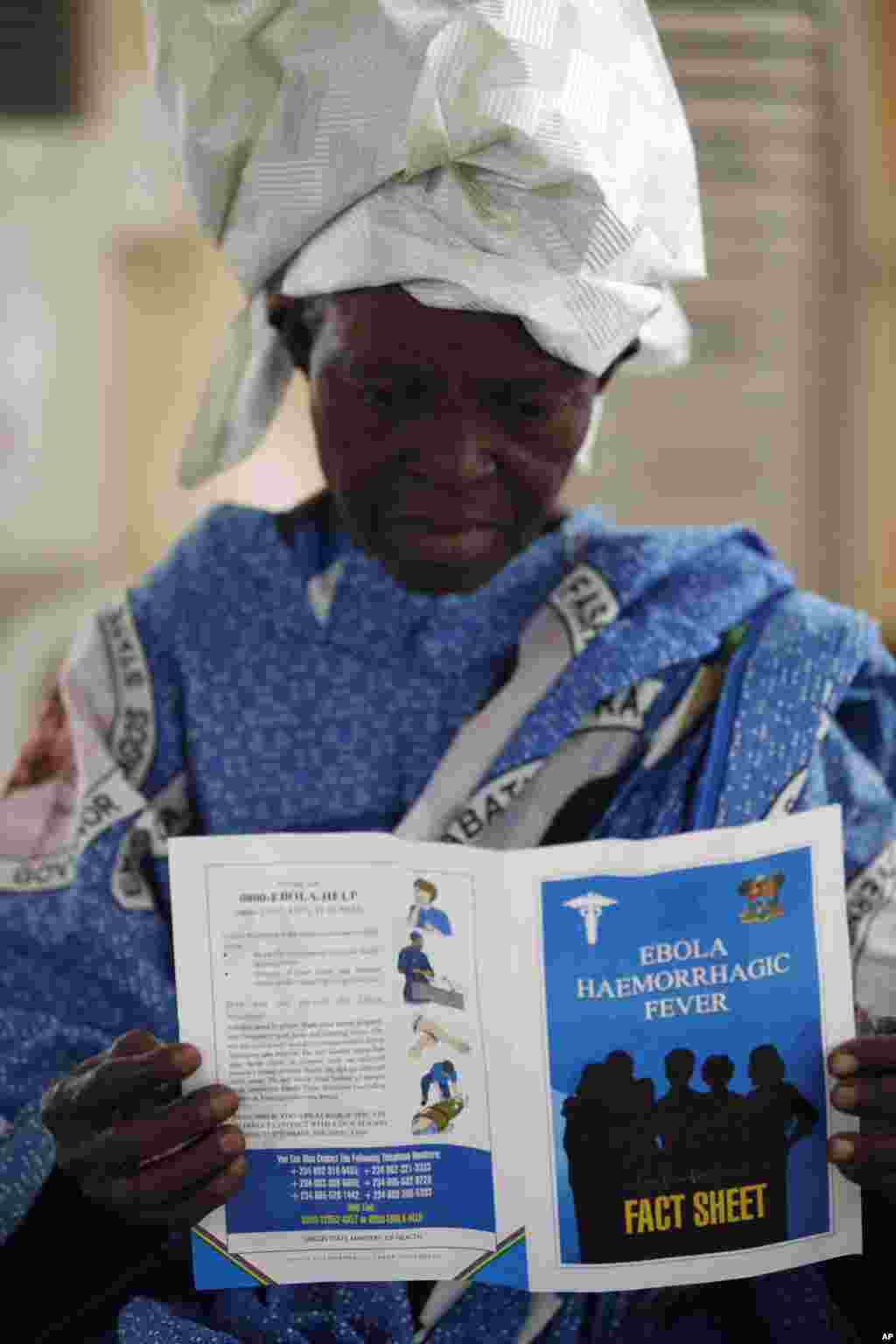 A woman reads a fact sheet for the Ebola virus during an awareness campaign in Lagos, Nigeria, Aug. 15, 2014. 