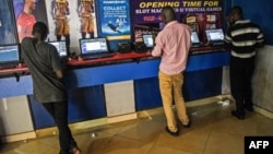 Des Ougandais sont en train de faire leurs paris à Kampala, Ouganda, le 13 mai 2018.