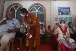 People sit in an observation room after getting a dose of the Covishield, AstraZeneca-Oxford's Covid-19 coronavirus vaccine at the Saifee Hospital after vaccinations restarted at all city private hospitals, in Mumbai on April 12, 2021. (Photo by Indranil