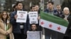 Demonstrators holding a Free Syria flag and placards reading "Stop the killing in Syria" take part in a protest outside the United Nations (UN) offices in Geneva, on Jan. 29, 2016 on the opening day of Syrian peace talks.