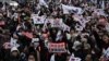 Simpatizantes del destituido presidente surcoreano Yoon Suk Yeol agitan banderas de Corea del Sur frente a una corte que celebró una audiencia el 18 de enero de 2025 para determinar si continúa detenido durante la investigación que se le sigue por declarar la ley marcial.
