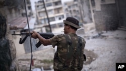 A Free Syrian Army fighter fires his weapon at Syrian Army positions in Aleppo, Syria. Piece by piece, Syria's rebels are slowly starting to expand their arsenal and get their hands on more advanced weapons, September 11, 2012