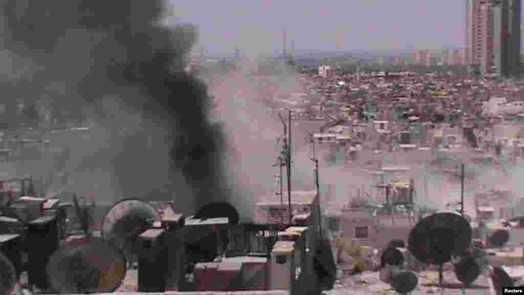 This image provided by Shaam News Network shows smoke rising from Juret al-Shayah in Homs, Syria, July 23, 2012.