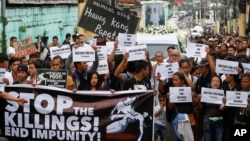 Protesters and supporters carry banners and placards as they march with the hearse of slain Kian Loyd delos Santos, a 17-year-old student, during his funeral, Aug. 26, 2017, in suburban Caloocan city north of Manila, Philippines. The killing of Kian has sparked an outcry against President Rodrigo Duterte's anti-drug crackdown, which has left thousands dead since assuming office in June of last year. 