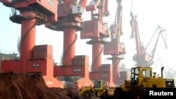FILE - Workers transport soil containing rare earth elements for export at a port in Lianyungang, Jiangsu province, China, Oct. 31, 2010. 