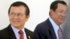 Cambodia's Prime Minister Hun Sen, right, walks with opposition Cambodia Rescue Party Deputy President Kem Sokha, left, during a break at National Assembly in Phnom Penh, Cambodia, Wednesday, Dec. 7, 2016. Cambodia's newly pardoned Kem Sokha has returned to parliament with a claim that he and Prime Minister Hun Sen have agreed to help reconcile their contending parties for the sake of benefiting the country. (AP Photo/Heng Sinith)