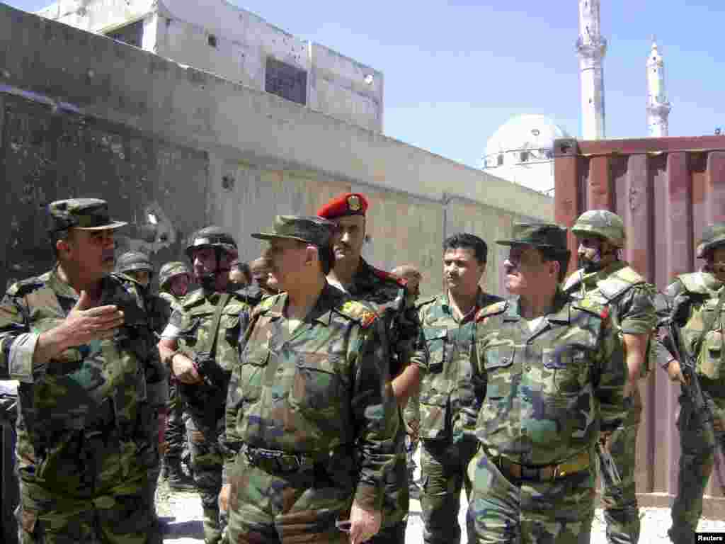 Syria's Defence Minister General Fahad Jassim al-Freij tours al Khaldia neighborhood in Homs city, August 5, 2013. (SANA)