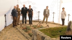 El juez chileno Mario Carroza y el director de servicios forenses inspeccionan la tumba de Pablo Neruda durante la exhumación de sus restos.
