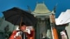 FILE - Gregg Donovan greets tourists on a warm day in Hollywood outside the TCL Chinese Theatre in Los Angeles, Oct. 2, 2014. The theater, which opened in 1927, is one of the first stops for tourists visiting Los Angeles.