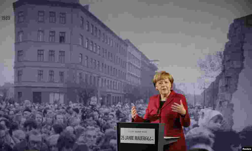 German Chancellor Angela Merkel speaks in front of a photograph showing Bernauer Strasse in November 1989 at the exhibition opening during a ceremony marking the 25th anniversary of the fall of the Berlin Wall at a memorial in Bernauer Strasse Berlin, Germany.