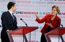 Democratic presidential candidate Sen. Elizabeth Warren, D-Mass., speaks as South Bend Mayor Pete Buttigieg listens during a Democratic presidential primary debate, Dec. 19, 2019, in Los Angeles.
