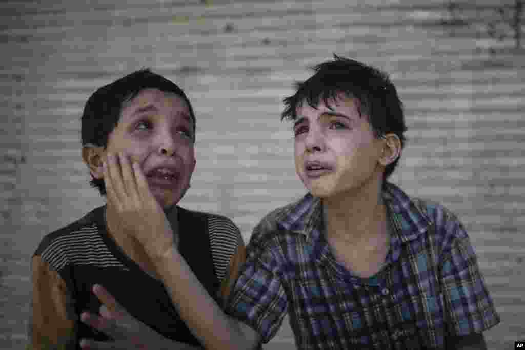 Dua bersaudara: Zeid Ali, 12 tahun (kiri) dan Hodayfa Ali, 11, menangis sedih setelah rumah mereka hancur dan beberapa anggota keluarga masih terkubur reruntuhan, dalam pertempuran pasukan Irak dan militan ISIS di Mosul.