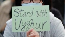 FILE - A man holds a sign during a rally to show support for Uighurs and their fight for human rights, Dec. 22, 2019, Hong Kong.