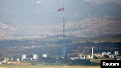Sebuah bendera Korea Utara terlihat berkibar di atas sebuah menara dekat desa Panmunjom di zona demiliterisasi (DMZ) yang memisahkan Korea Utara dan Kores Selatan, 55 kilometer dari kota Seoul (Foto: REUTERS/Lee Jae-Won).