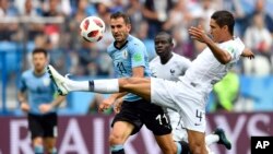 Raphael Varane, (derecha) de Francia, es desafiado por el uruguayo Cristhian Stuani durante el partido por cuartos de final entre Uruguay y Francia el viernes, 6 de julio de 2018, en Nizhny Novgorod, Rusia.