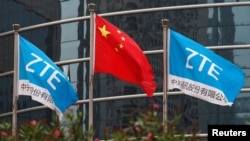 中國企業中興通訊在深圳的總部外飄揚的該公司旗幟和中國國旗。（2016年4月28日）
