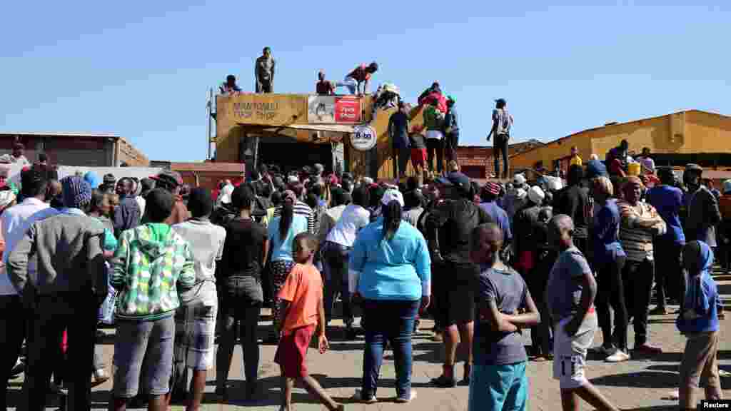 Les manifestant tentent d'accéder à une boutique lors des manifestations à Atteridgeville en Afrique du Sud, le 21 juin 2016.