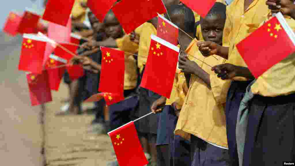 Drapelets chinois en main, les enfants libériens attendent l'arrivée du président chinois Hu Jintao à Monrovia, 1er février 2007. 
