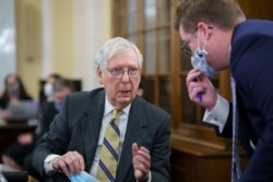FILE - Senate Minority Leader Mitch McConnell, R-Ky., turns to an aide in Washington, March 7, 2021.