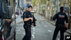 Polisi bersenjata melakukan patroli di kawasan La Rambla, Barcelona hari Jumat (18/8). 