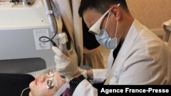 This photo taken on Nov. 11, 2021 shows Kayla Zhang, a finance worker, receiving laser facial treatment at a beauty clinic in Shanghai.