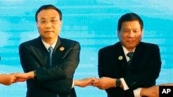 老撾萬象舉行的東盟會議上，中國總理李克強(左)和菲律賓總統杜特爾特(右)手拉手(資料照片)