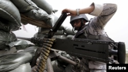 A Saudi soldier loads ammunition at their position at Saudi Arabia's border with Yemen, April 6, 2015.