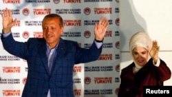 Turkey's Prime Minister Recep Tayyip Erdogan celebrates his election victory flanked by his wife Ermine in front of his party's headquarters in Ankara August 10, 2014.