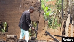 Umwe mu baturage ari mu itongo nyuma yo gusenyerwa n'inyeshyamba za ADF zahitanye abarenga 35 mu gace atuyemo