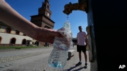 Turista puni vodu kod česme u Milanu, u Italiji, 25. juna 2022. (Foto: AP/Luca Bruno)