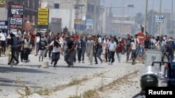 Para pendukung kelompok radikal Ansar al-Sharia bentrok dengan polisi Tunisia hari Minggu (19/5). 