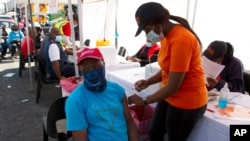 FILE - A patient receives a Johnson & Johnson vaccine at a pop-up vaccination center, at the Bare taxi rank in Soweto, South Africa, Aug. 20, 2021. 