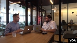 Brand strategist Phil Pallen (left) travels the world and works in the co-working spaces of a company called WeWork, seen here at a location in downtown Los Angeles. (M. O'Sullivan / VOA)