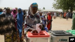 Seorang perempuan memasukkan surat suara dalam pemilihan presiden dan anggota DPR Nigeria di Damilu Yola, Nigeria, 23 Februari 2019.
