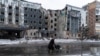 A woman walks past a building damaged by a Russian military strike in the town of Pokrovsk