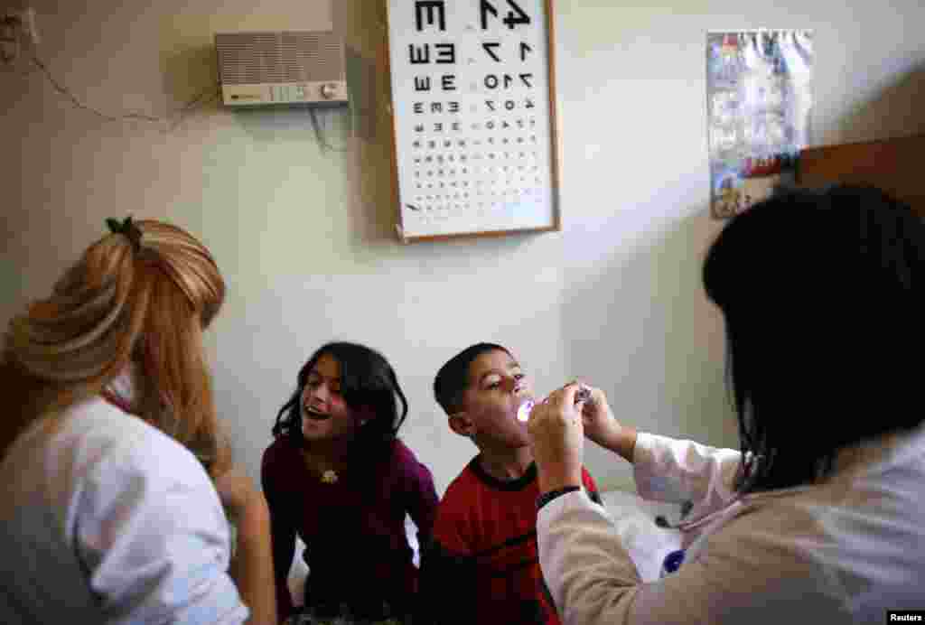 Bulgarian doctors perform medical checkups on Syrian children at a refugee centre in Sofia October 26, 2013. 
