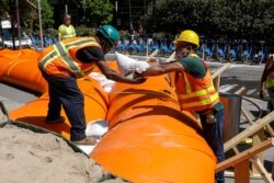 Workers stack sandbags around a hydro-dam as they prepare for Tropical Storm Isaias in the lower Manhattan area of New York City, Aug 3, 2020.
