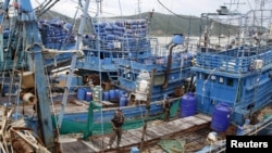Para petugas kepolisian berdiri di sebuah kapal nelayan di Songkhla, selatan Thailand, 23 Desember 2015, menyusul laporan mengenai kerja paksa di industri penangkapan ikan negara itu.