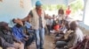 A UNICEF worker recruits participants for a community watch committee in Daro, a village in Guinea’s forest region. (Christophe Boulierac / UNICEF) 